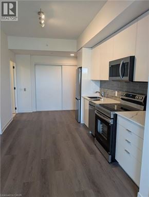 Brantford condo for rent - A kitchen with white cabinets and a black oven.