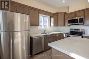 Thorold (Rolling Meadows) apartment for rent - A kitchen with a refrigerator, oven, and microwave.