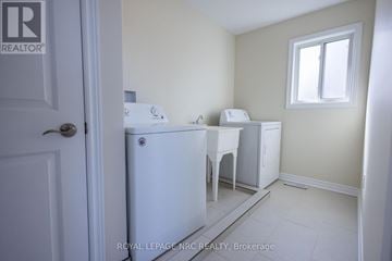 Thorold (Rolling Meadows) apartment for rent - A white refrigerator sits in a kitchen with a white door and a window.