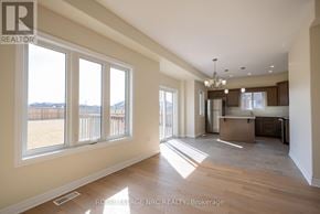 Thorold (Rolling Meadows) apartment for rent - A spacious, empty room with a kitchen area in the background.