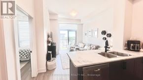 Hamilton (Waterdown) condo for rent - A modern kitchen with a sink, a window, and a checkered floor.