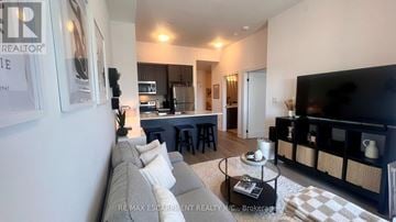 Hamilton (Waterdown) condo for rent - A living room with a grey couch and a black fireplace.