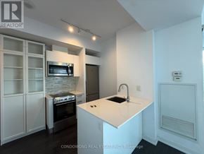 Toronto (Church-Yonge Corridor) condo for rent - A modern kitchen with white cabinets and a central island.