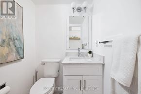Toronto (Don Valley Village) condo for rent - A white bathroom with a toilet, sink, and mirror.