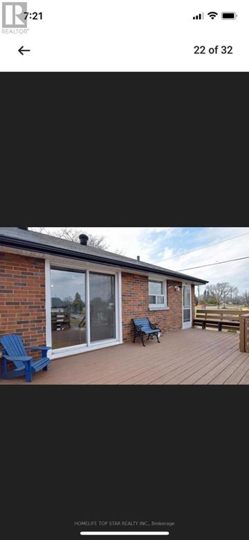 Oshawa (Mclaughlin) apartment for rent - A house with a red brick exterior and a wooden deck with two blue chairs.