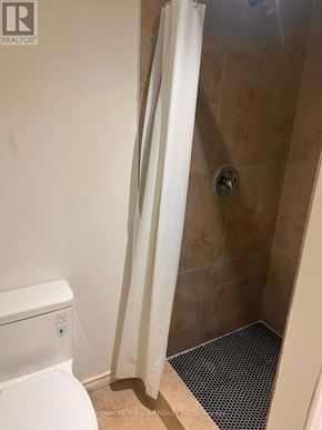 Oshawa (Mclaughlin) apartment for rent - A bathroom with a toilet, a shower curtain and a shower mat.