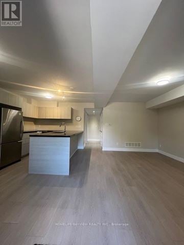 Toronto (East York) triplex for rent - A spacious kitchen with a refrigerator, sink, and countertop.