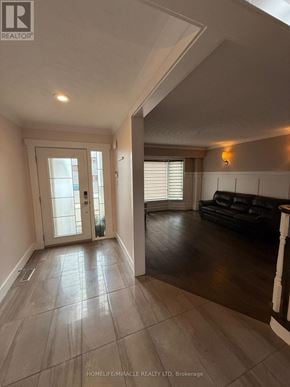 Burlington (Headon) apartment for rent - A spacious living room with a black couch and a tiled floor.
