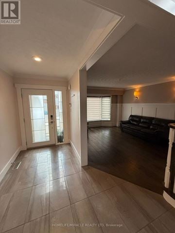 Burlington (Headon) apartment for rent - A spacious living room with a black couch and a tiled floor.