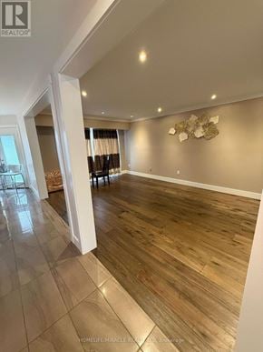 Burlington (Headon) apartment for rent - A spacious room with wooden flooring and a wall decoration.