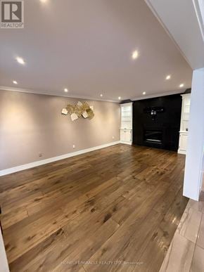 Burlington (Headon) apartment for rent - A spacious room with wooden flooring and a wall-mounted light fixture.