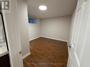 Brampton (Westgate) apartment for rent - A room with wooden flooring and white walls, with a door on the left and a window on the right.