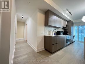 Toronto (Annex) condo for rent - A modern kitchen with dark wood cabinets and a white countertop.