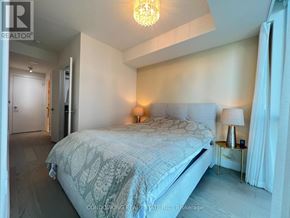 Toronto (Annex) condo for rent - A bedroom with a large bed and a chandelier.