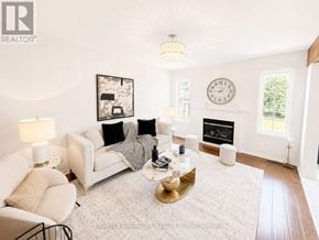 Oshawa (Pinecrest) apartment for rent - A living room with a white couch, a coffee table, and a fireplace.