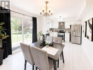 Oshawa (Pinecrest) apartment for rent - A dining room with a table set for two and a kitchen in the background.