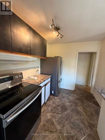 Belleville (Belleville Ward) apartment for rent - A kitchen with a black fridge and stove top oven.