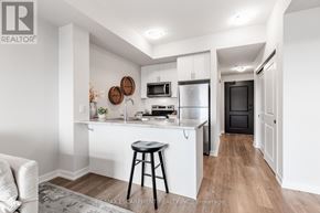 Hamilton (Stoney Creek) condo for rent - A kitchen with white cabinets and a black stool.