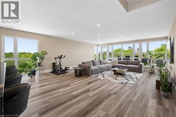 Kitchener condo for rent - A spacious living room with a large couch and a television.
