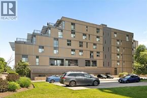 Kitchener condo for rent - A modern apartment building with cars parked in front.