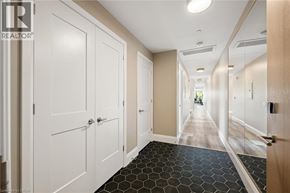 Kitchener condo for rent - A hallway with white doors and a black and white floor.