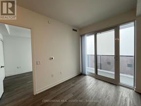 Toronto (Waterfront Communities) condo for rent - A room with a sliding glass door and wood flooring.