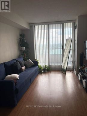 Toronto (Agincourt North) condo for rent - A living room with a blue couch and a wooden floor.