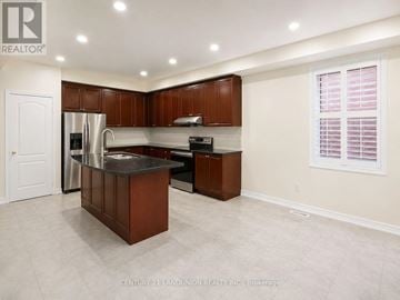 Oakville (Wm Westmount) apartment for rent - A kitchen with brown cabinets and a stainless steel sink.