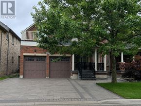 Oakville (Wm Westmount) apartment for rent - A house with a brick wall and a tree in front.