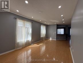 Brampton (Northwest Brampton) apartment for rent - A spacious room with wooden floors and white walls.