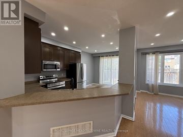 Brampton (Northwest Brampton) apartment for rent - A kitchen with brown cabinets and a countertop is shown.