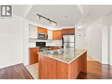 Vancouver apartment for rent - A modern kitchen with wooden cabinets and a granite countertop.
