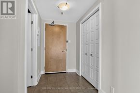 Ottawa condo for rent - A hallway with a wooden door and white walls.