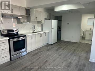 Oshawa (Central) apartment for rent - A kitchen with a stove top oven and a refrigerator.