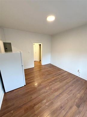 Winnipeg apartment for rent - A room with wooden flooring and a white refrigerator.