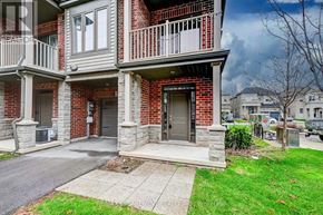 Hamilton (Waterdown) townhouse for rent - A brick house with a grey front porch and a black door.