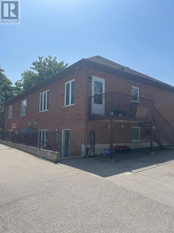 Grimsby (Grimsby East) fourplex for rent - A red brick building with a balcony on the second floor.