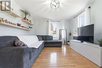 Pembroke apartment for rent - A living room with a grey couch and a television on a white stand.