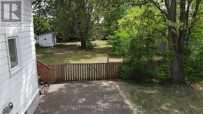 Pembroke apartment for rent - A backyard with a fence and a tree.
