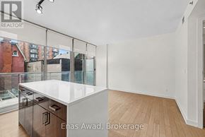 Ottawa condo for rent - A white kitchen with a glass wall and wooden floors.