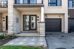 Burlington (Lasalle) townhouse for rent - A modern house with a black garage door and a glass door.
