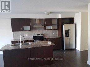 Hamilton (Stoney Creek) townhouse for rent - A kitchen with brown cabinets and a granite countertop.