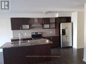 Hamilton (Stoney Creek) townhouse for rent - A kitchen with brown cabinets and a granite countertop.