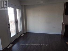 Hamilton (Stoney Creek) townhouse for rent - A room with a sliding glass door and wooden flooring.