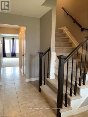 Niagara Falls (Forestview) townhouse for rent - A staircase with a beige carpet and black railings.