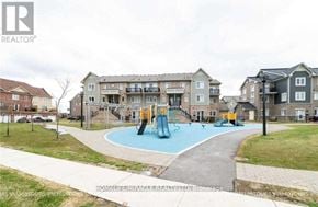 Brampton (Sandringham-Wellington) townhouse for rent - A playground with a blue slide and a yellow slide in front of apartment buildings.