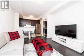 Brampton (Sandringham-Wellington) townhouse for rent - A modern living room with a white couch and a black and red plaid blanket on the floor.