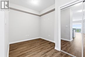 Hamilton (Waterdown) condo for rent - A room with wooden flooring and white walls, with a door leading to another room.