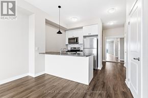 Hamilton (Waterdown) condo for rent - A modern kitchen with white cabinets and a wooden floor.