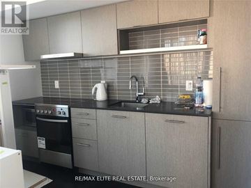 Toronto (Church-Yonge Corridor) condo for rent - A kitchen with a black counter top and grey cabinets.